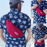Man wearing a red waist bag with a palm tree pattern shirt on a beach. 