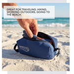 Blue pouch being held on a sandy beach with text about its uses. 