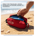 Red Breezy Packs pouch on a sandy beach with text about its uses.
